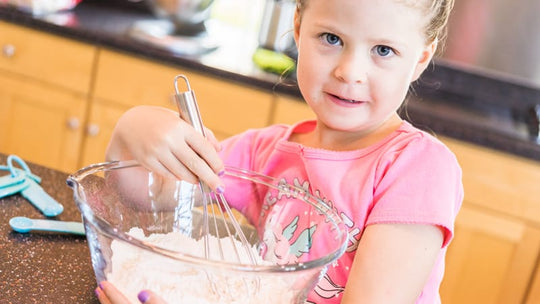 Little girl helping bake mini pound cakes in silicone molds shaped as on owls_1575040495
