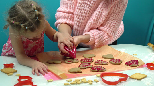 Girl,And,Mom,Decorate,Cookies,In,The,Form,Of,A