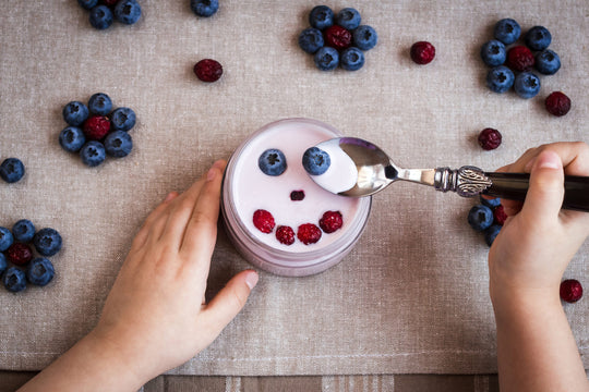 Blueberry,Yogurt,With,A,Smiling,Face.,Child,Hands,With,Yogurt.