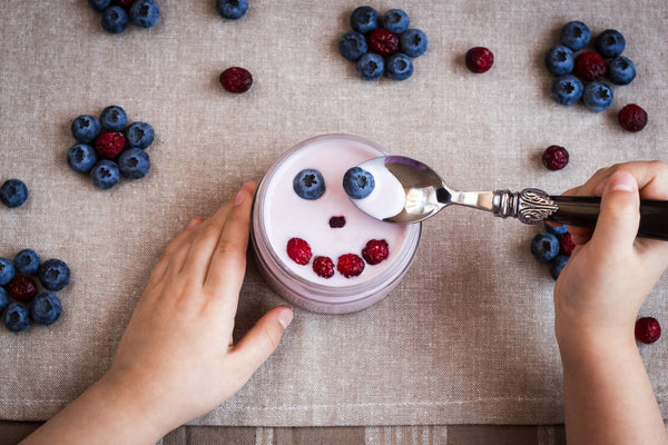 Blueberry,Yogurt,With,A,Smiling,Face.,Child,Hands,With,Yogurt.